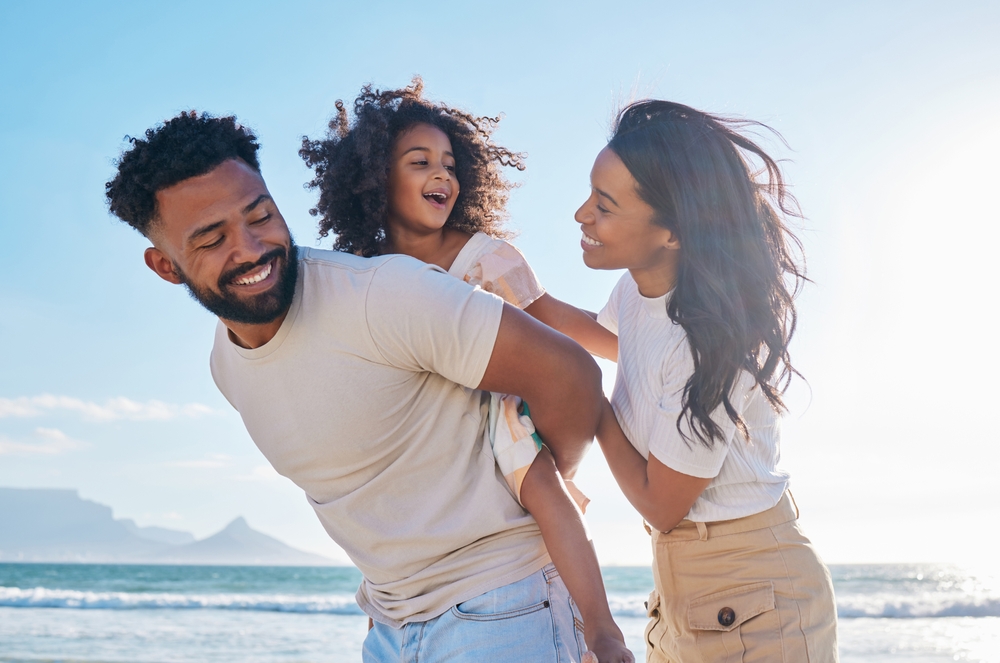A joyful family enjoys a sunny day at the beach, symbolizing healthy smiles and the confidence that comes from expert dental care – Endodontist Long Beach.